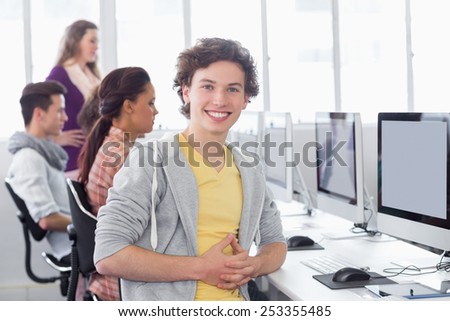 Student smiling at camera in computer class at the college