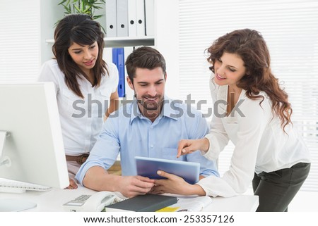 Smiling teamwork using digital tablet in the office