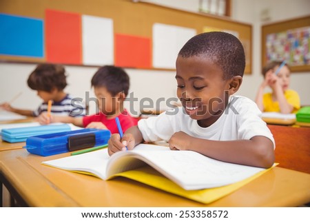 Cute pupils drawing at their desks at the elementary school