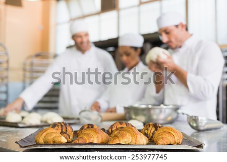 Team of bakers working at counter in the kitchen of the bakery