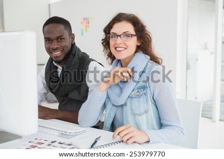 Smiling teamwork using computer monitor in the office