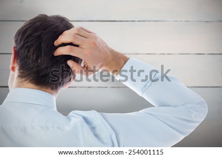Businessman scratching his head against painted blue wooden planks