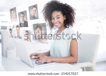 Happy businesswoman working on her laptop against profile pictures