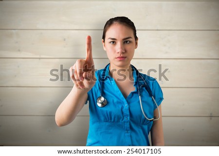 Serious doctor pointing against bleached wooden planks background