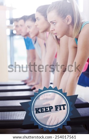 The word keep fit and instructor with fitness class performing step aerobics exercise against badge