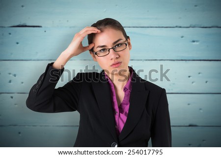 Businesswoman thinking against painted blue wooden planks