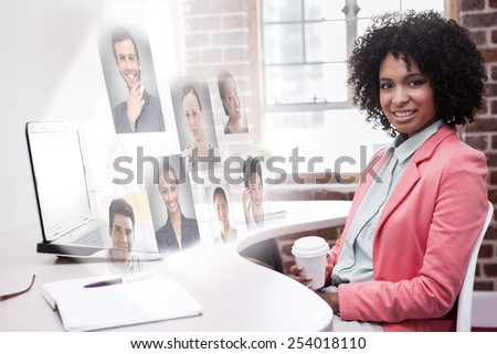 Happy casual businesswoman sitting at desk against profile pictures