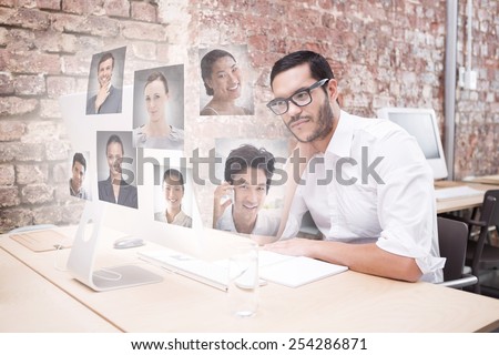 Businessman using computer at desk against profile pictures