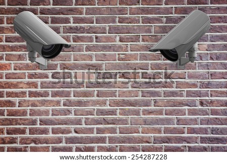 CCTV camera against red brick wall