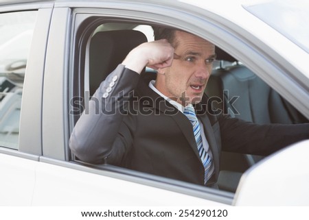 Businessman experiencing road rage in his car