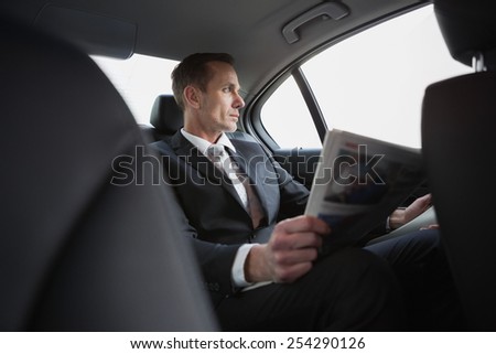 Businessman looking out the window in his car