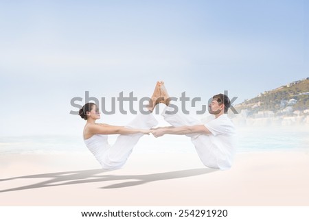 Peaceful couple sitting in boat position together against beautiful beach and blue sky