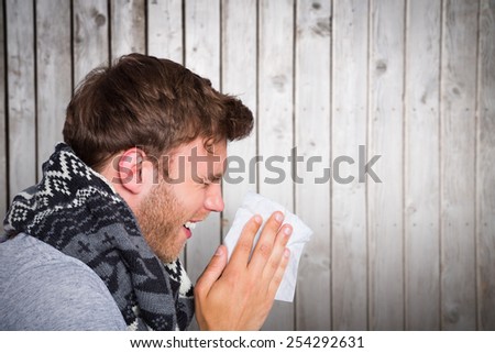Close up side view of man blowing nose against wooden planks