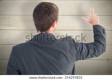 Businessman pointing with his fingers against bleached wooden planks background
