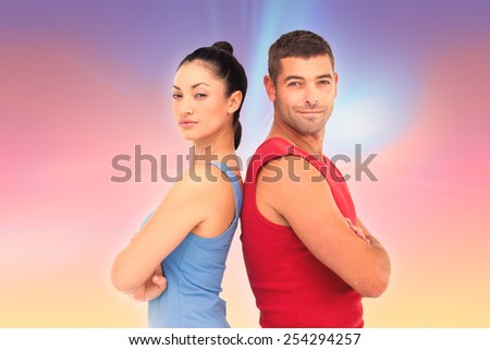 Fit man and woman smiling at camera together against abstract background