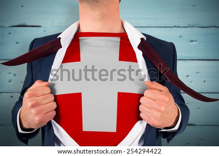 Businessman opening shirt to reveal swiss flag against painted blue wooden planks