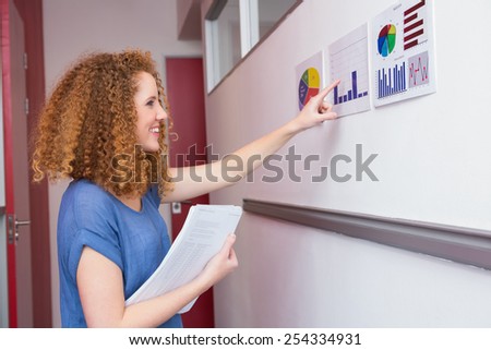 Cheerful student pointing the graphic at the college