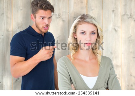 Young couple having an argument against pale wooden planks