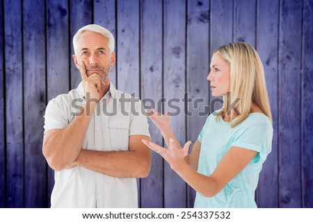 Unhappy couple having an argument with man not listening against wooden planks background