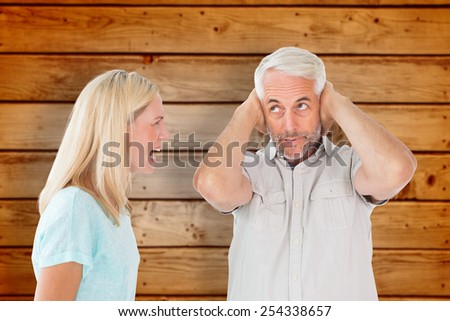Unhappy couple having an argument with man not listening against wooden planks background