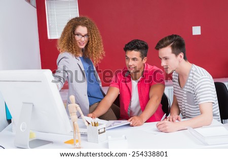 Smiling students working together on computer at the college