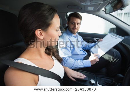 Young woman getting a driving lesson in the car