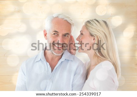 Woman whispering a secret to husband against light circles on grey background