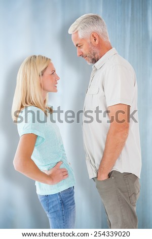 Unhappy couple having an argument against bleached wooden planks background