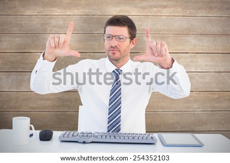 Businessman working at his desk against wooden surface with planks