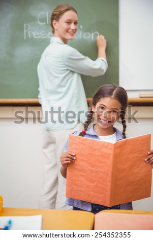Cute pupil smiling at camera during class presentation at the elementary school