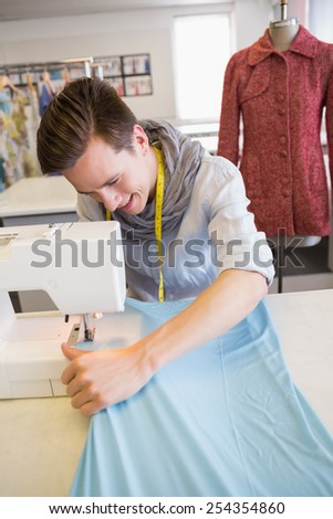 Smiling student using sewing machine at the college