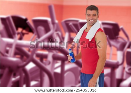 Fit man smiling at camera against close up of treadmills in a fitness centre