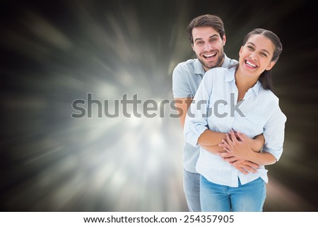 Cute couple hugging and smiling at camera against black abstract light spot design