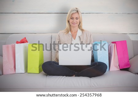 Woman shopping online against painted blue wooden planks