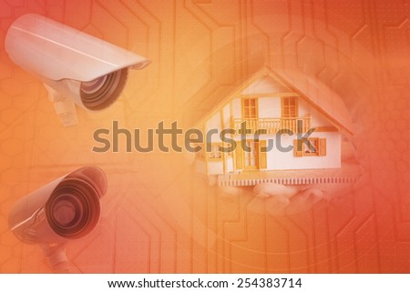 Hands showing a miniature model home against circuit board on futuristic background