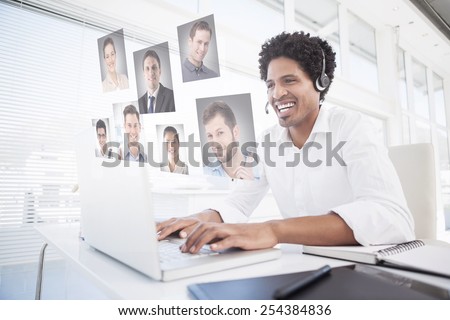Happy businessman working at his desk wearing headset against profile pictures