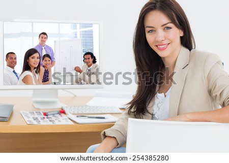 Young businessman presenting figures against female artist at desk with computer in the office