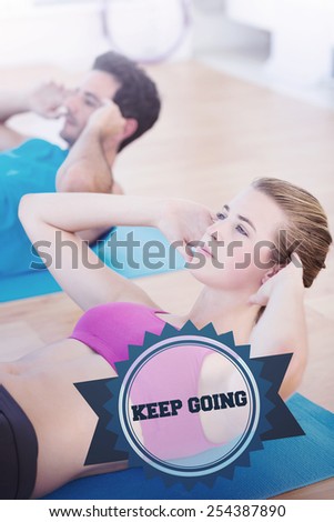 The word keep going and determined young couple doing sit ups at gym against badge