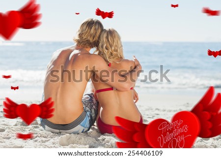 Cute valentines message against rear view of a young couple sitting on the beach