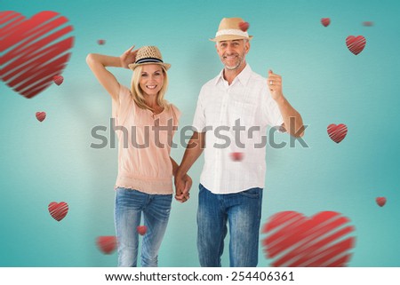 Happy couple walking holding hands against blue vignette background
