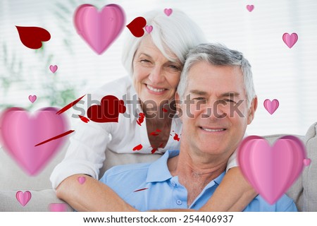 Portrait of a woman hugging husband against love heart pattern