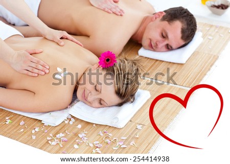 Beautiful young couple receiving a back massage against heart
