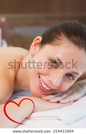 Beautiful woman lying on massage table at spa center against heart
