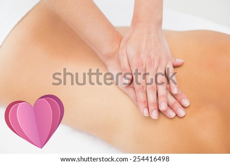 Woman receiving back massage at spa center against heart