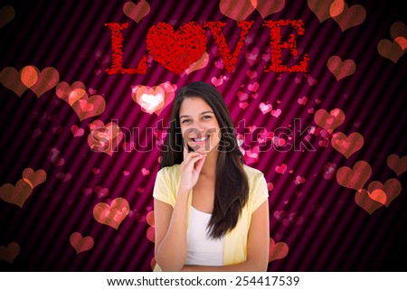 Happy casual woman thinking with hand on chin against digitally generated girly heart design