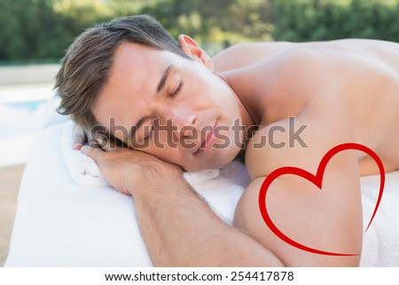Peaceful man lying on massage table poolside against heart