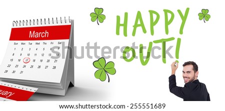 Happy businessman writing with marker against shamrock
