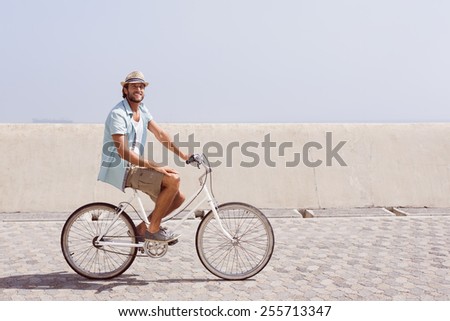 Handsome man on a bike ride on the pier on a sunny day