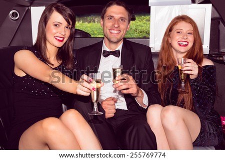Pretty girls with ladies man in the limousine on a night out