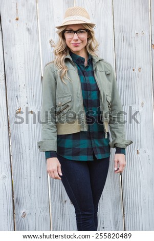 Portrait of blonde posing and looking at camera against bleached wooden planks